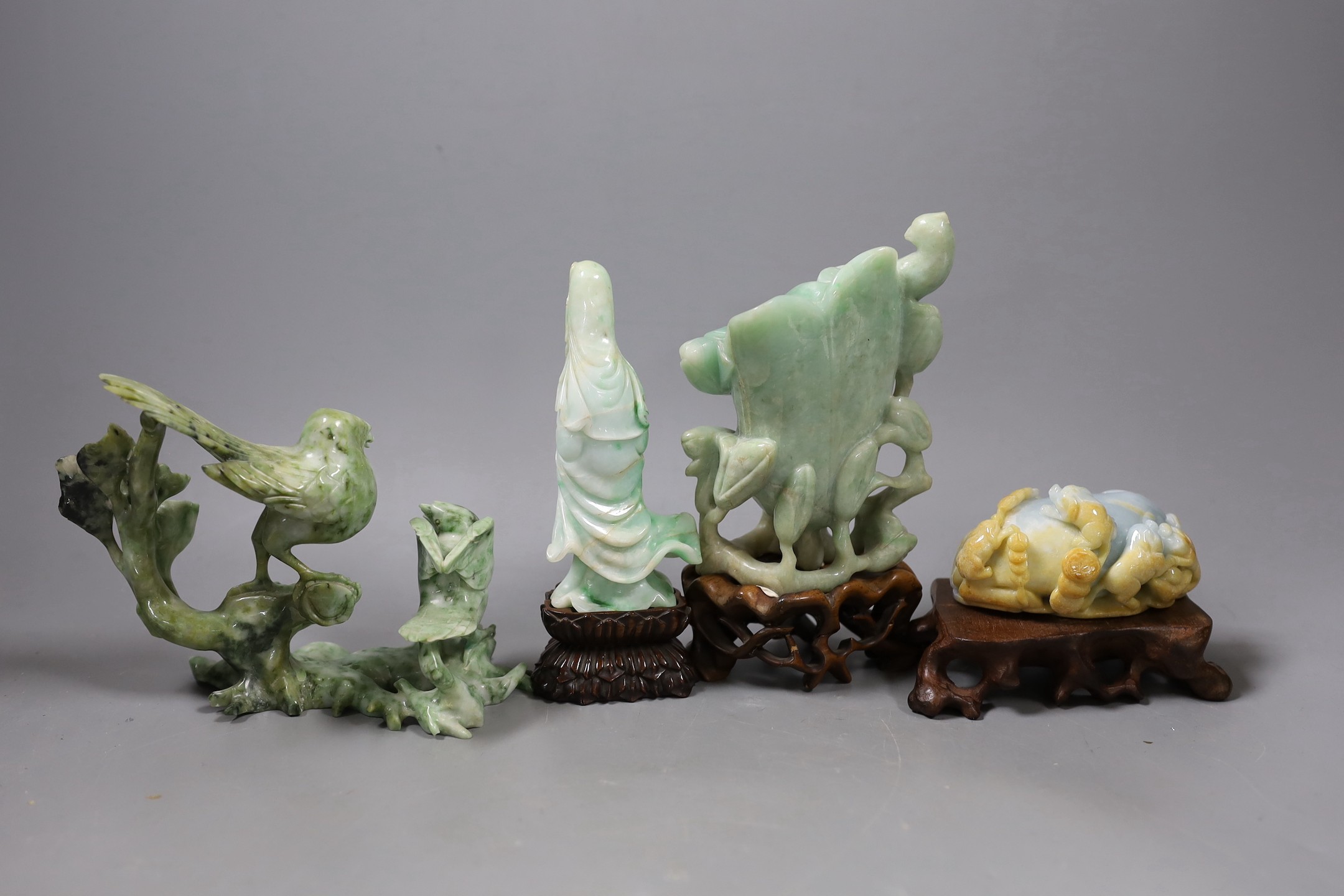 Four Chinese jadeite carvings, three on hardwood stands. Including a pig and piglets, two birds on a branch, a magnolia vase and a figure of Guanyin, Tallest 17.5cm including stand